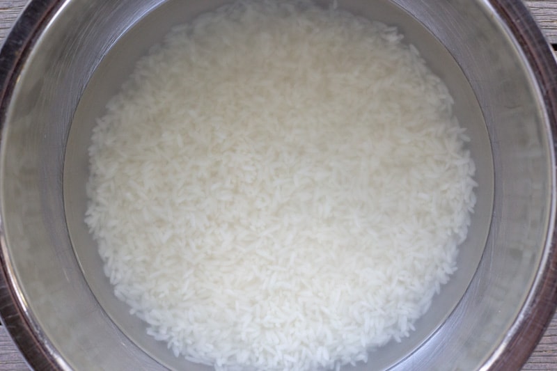 Soaking sticky rice in a metal bowl with water