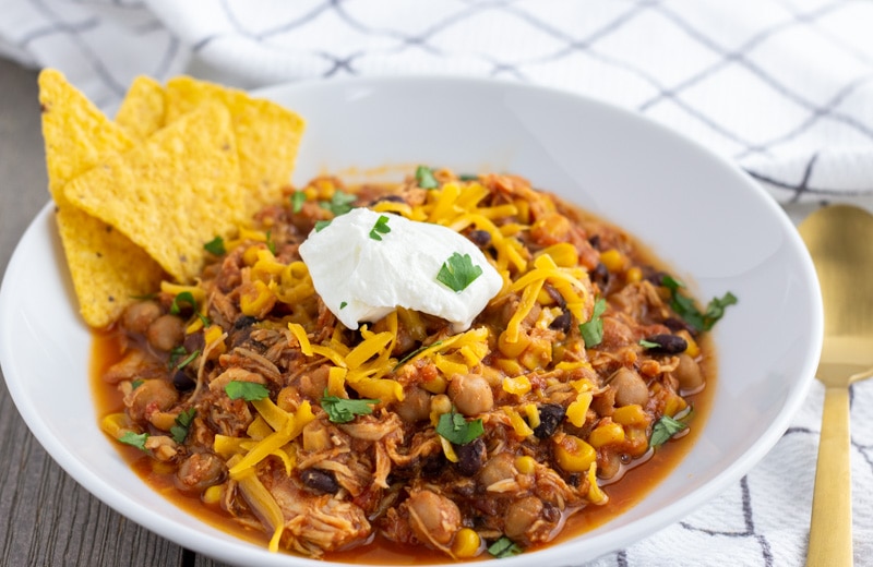 Chicken Taco Chili made in the Instant Pot or Crock Pot. Tender pieces of shredded chicken with corn, black beans, garbanzo beans, in a tomato base sauce.